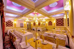 皮特什蒂Hotel Rehoma的宴会厅配有白色桌椅和紫色天花板