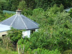 班特里Drombrow Cottage的白色房子,有树木的黑色屋顶