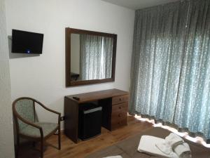 巴多尼奇亚落叶松酒店的一间设有镜子、梳妆台和椅子的房间