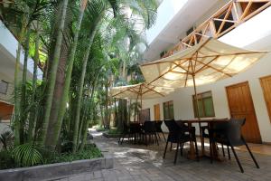 纳斯卡纳斯卡标准卡萨安迪娜酒店的一个带桌椅和棕榈树的庭院