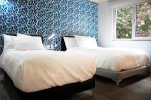 墨西哥城Casa Condesa Michoacan 113的卧室内的两张床,配有蓝色和白色的壁纸