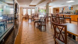 布雷登顿布雷登顿贝斯特韦斯特优质酒店的一间带木桌椅的餐厅和一间酒吧