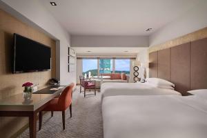 台北台北君悦酒店的酒店客房设有两张床、一张桌子和一台电视。