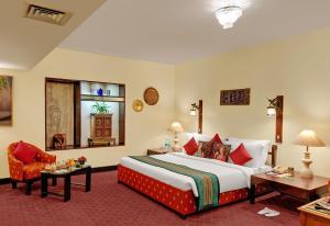 钦奈帕拉瓦大使酒店的酒店客房带一张大床和一把椅子