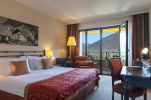 洛迦诺Boutique-HOTEL REMORINO, a Private Selection Hotel的配有一张床、一张书桌和一扇窗户的酒店客房