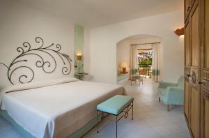 坎尼吉翁卡拉迪法尔科度假酒店的卧室配有白色大床和蓝色椅子
