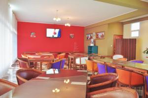 塔那那利佛Anouk Hotel的一间带桌椅和红色墙壁的餐厅