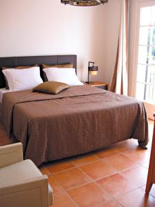 圣马克西姆Lagrange Vacances Carré Beauchêne的一间卧室配有一张带棕色毯子的大床