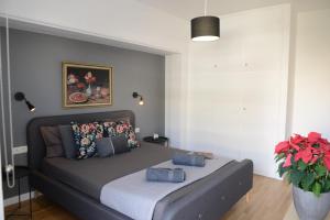 雅典Boutique Apartment in Chalandri的一间卧室配有床和花瓶