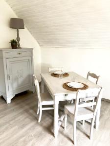 AnthisnesGîte d'Anthisnes的白色的餐桌、椅子和白色的橱柜