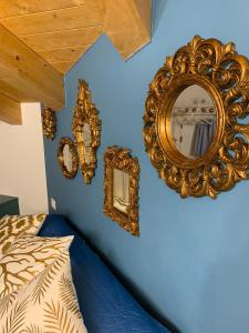 基奥贾La Bella Vita - La Casetta的一间蓝色墙壁上配有金色镜子的卧室