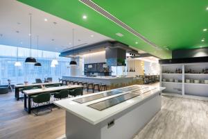 迪拜Studio M Arabian Plaza Hotel & Hotel Apartments的一间设有桌子和绿色天花板的餐厅