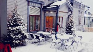 萨翁林纳Cafe-Restaurant & Hotel Saima的房屋前雪地里的桌椅