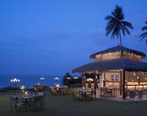 本托塔Taj Bentota Resort & Spa的大楼前设有桌椅的餐厅