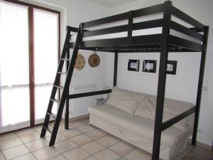卡罗纳Monolocale Energy的一间卧室配有一张双层床和梯子