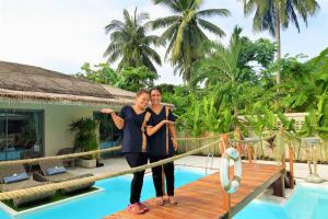 拉迈AMAYA Resort的两个女人站在泳池旁的桥上