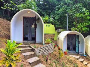 峇都丁宜Eco Capsule Resort at Teluk Bahang, Penang的一个小房子,有楼梯通往门