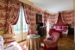 普罗旺斯艾克斯伽里奇别墅Spa酒店的客厅配有红色窗帘、椅子和桌子
