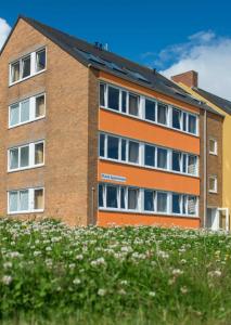 黑尔戈兰岛克拉西克公寓的橙色砖砌的建筑,设有窗户和鲜花