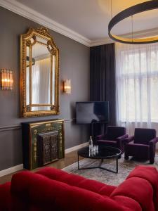 布达佩斯Hotel Collect - Adults Only的客厅配有红色的沙发和镜子