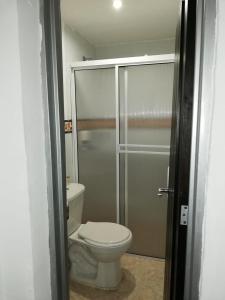 图卢阿Hotel Cafe Plaza的一间带卫生间和玻璃淋浴间的浴室