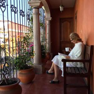 瓦哈卡市拉斯美洲旅馆的坐在长凳上读书的女人