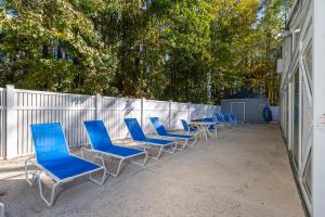 默特尔比奇Country Club Villas by Capital Vacations的围栏旁边一排蓝色的桌椅
