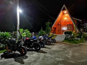 清刊Bansuanphuhong Resort的停在小屋前的一组摩托车