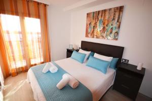 坎布里尔斯La Torre Oceanside的一间卧室配有一张带蓝色和白色枕头的床