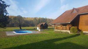 ČačinciKRAJNA KUĆA ZA ODMOR的谷仓和房子旁边的游泳池
