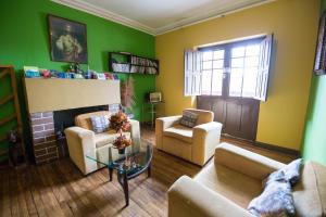 库斯科图利斯提克雷科莱塔旅舍的客厅设有绿色的墙壁和壁炉