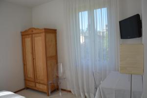 卢加诺瑟尔瓦别墅酒店的一间卧室配有梳妆台和带电视的窗户。
