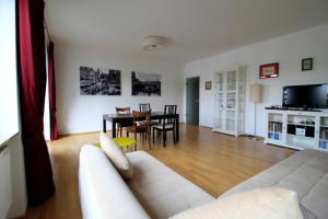 维尔茨堡Luxury city apartment - view of river and castle的客厅配有白色的沙发和桌子