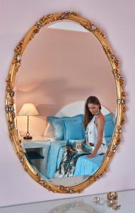 佩里萨维嘉杰拉海滩度假酒店的坐在镜子里床上的女人