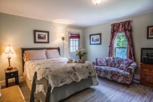 德兰赫勒Heartwood Inn的卧室配有床、椅子和窗户。