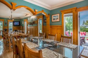 德兰赫勒Heartwood Inn的一间拥有绿色墙壁和木桌及椅子的用餐室