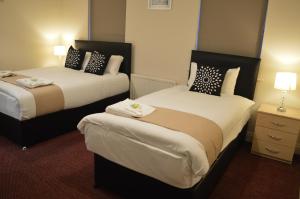 泰恩河畔纽卡斯尔The Townhouse Newcastle的酒店客房设有两张床和两盏灯。
