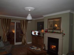德罗赫达Chez Sé的客厅设有壁炉和电视。