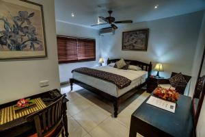 努库阿洛法海景餐厅山林小屋的一间卧室配有一张床、一张桌子和一张四柱床。