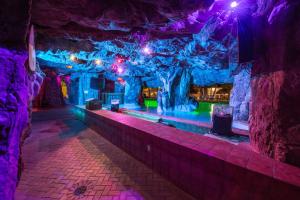 沃尔顿堡滩The Island Resort at Fort Walton Beach的洞穴内一间紫色和绿灯的房间