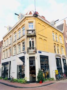 阿姆斯特丹Bee Amsterdam - central apartment in the trendy Jordaan的城市街道上的一座黄色和白色的建筑