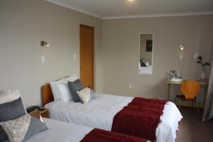 新普利茅斯Jenny's Bed & Breakfast的酒店客房,配有两张床和椅子