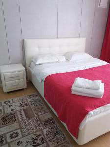阿斯塔纳Highvill AST的卧室配有一张大白色床和红色毯子
