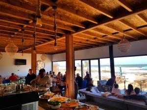 米勒福特Greenwave Ecolodge的一群人坐在海滩餐厅里