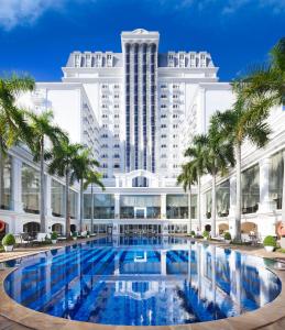 顺化印度希纳宫殿酒店的一座带游泳池和棕榈树的大型建筑