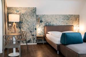 梅拉诺Stay COOPER l Guesthouse zum Löwen的卧室配有1张床、1张桌子和1把椅子