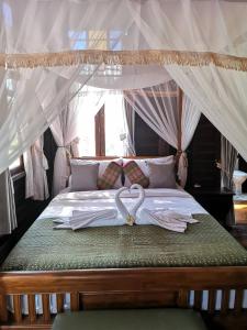 彭世洛Baan Sithepaban Guesthouse的一张床上有两把白色的伞