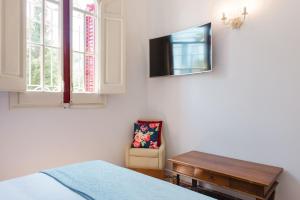 圣库加特德尔瓦勒斯Hotel Torre Barcelona的一间卧室配有一张床、一台电视和一把椅子