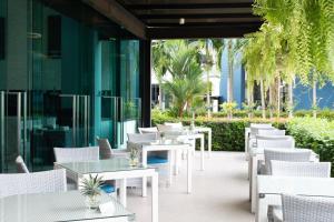 奥南海滩BlueSotel Krabi AoNang Beach- SHA Extra Plus的户外庭院配有白色的桌椅。