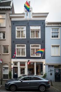 阿姆斯特丹阿米司塔特酒店的停在一座有彩虹旗的建筑前面的汽车